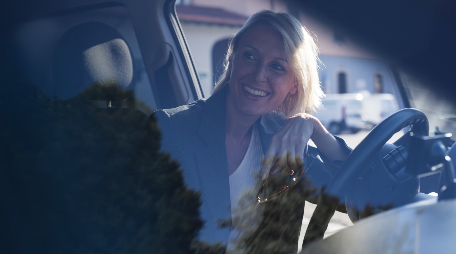 Lächelnde Frau im Auto hinter dem Lenkrad